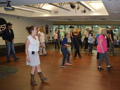 Amie teaches line dance class cowboy in rear